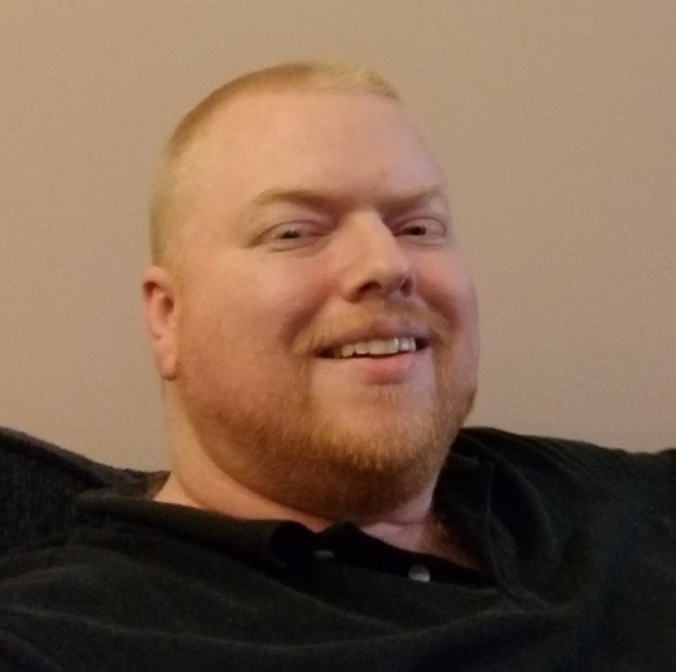 Man sitting on couch in black shirt